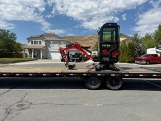 Red excavator on flatbed trailer