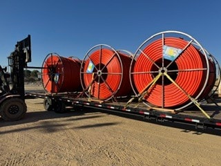Forklift loading orange cable spools