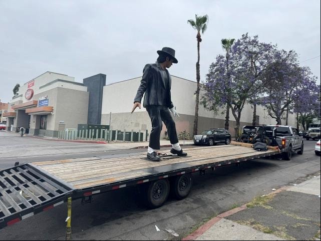 Flatbed trailer with statue in urban setting