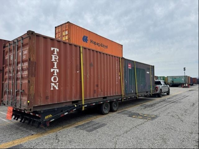 Triton shipping containers on flatbed at yard